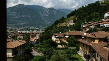 A residential area with houses, a small courtyard, and mountains in the background.
