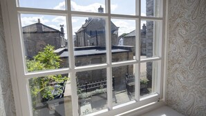 A window with a view of traditional buildings and a garden. - The Carriage House - sleeps 4 guests  in 2 bedrooms (Leyburn)