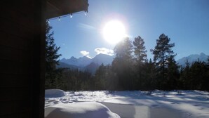 Un paysage enneigé avec des montagnes en arrière-plan et un ciel dégagé.