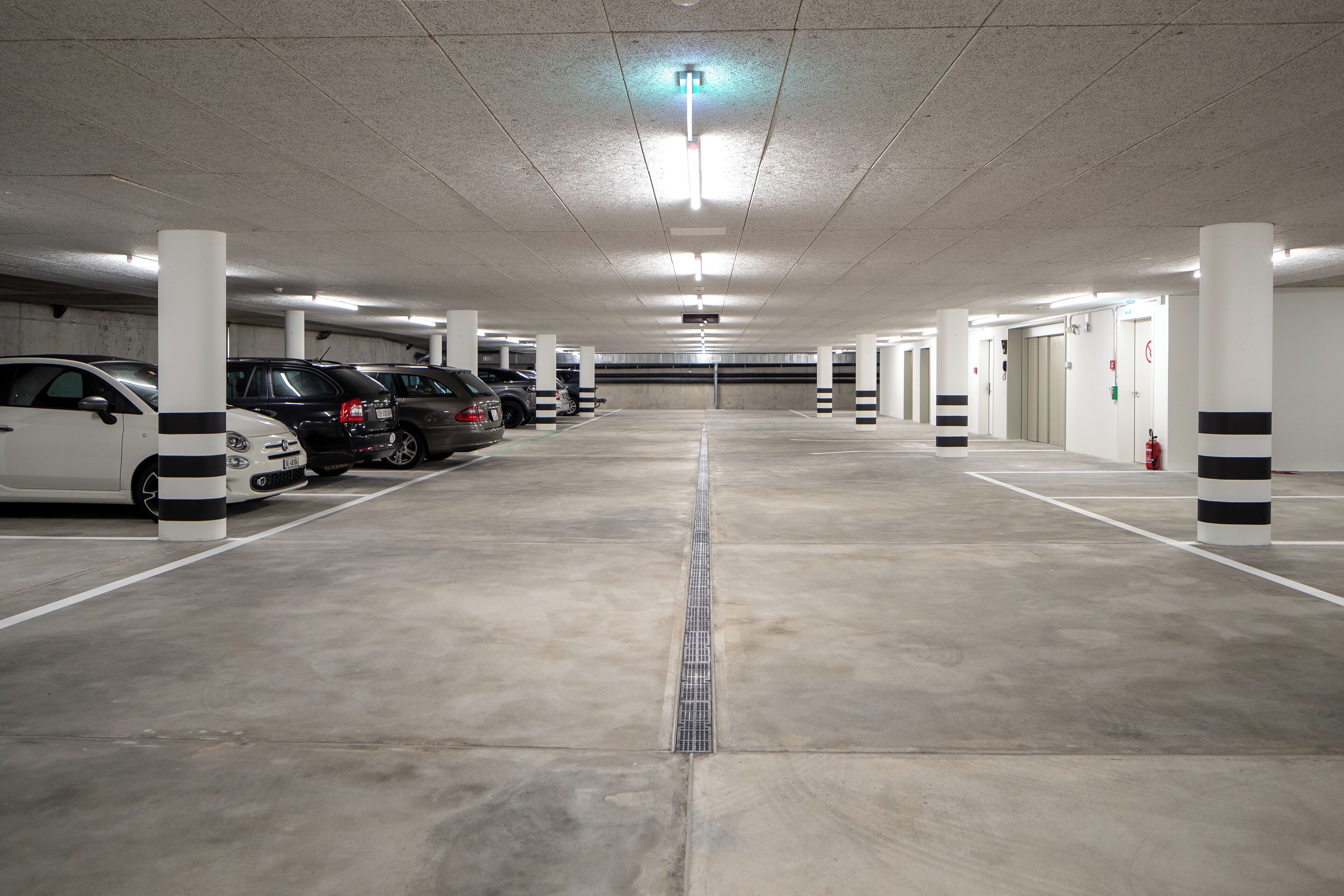 Un estacionamiento de varios niveles con varios coches aparcados en sus plazas designadas.