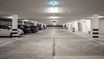 Un estacionamiento de varios niveles con varios coches aparcados en sus plazas designadas.