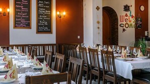 A restaurant with multiple tables set for dining, featuring a menu on the wall and a 'Welcome' sign. - Gasthof-Pension Kirchenwirt (Niederaichbach)