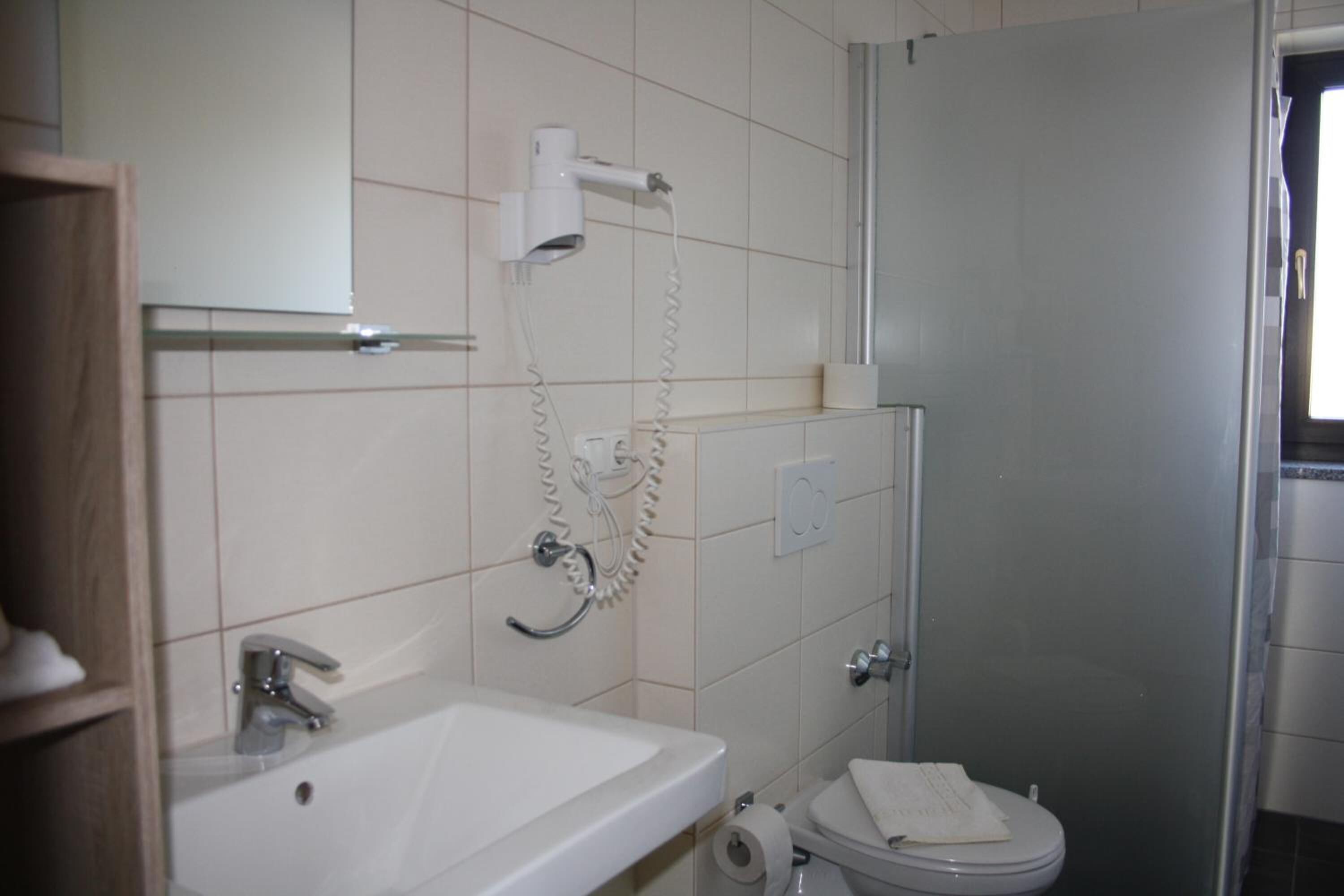Un baño con lavabo, inodoro y ducha.