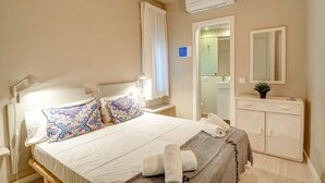A hotel room with a bed, a bedside table, a mirror, and a wardrobe. - La Gioia 1 by Hello Homes Sitges (Sitges)