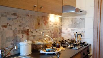 A kitchen with wooden cabinets, a tiled backsplash, a stove, and a sink.