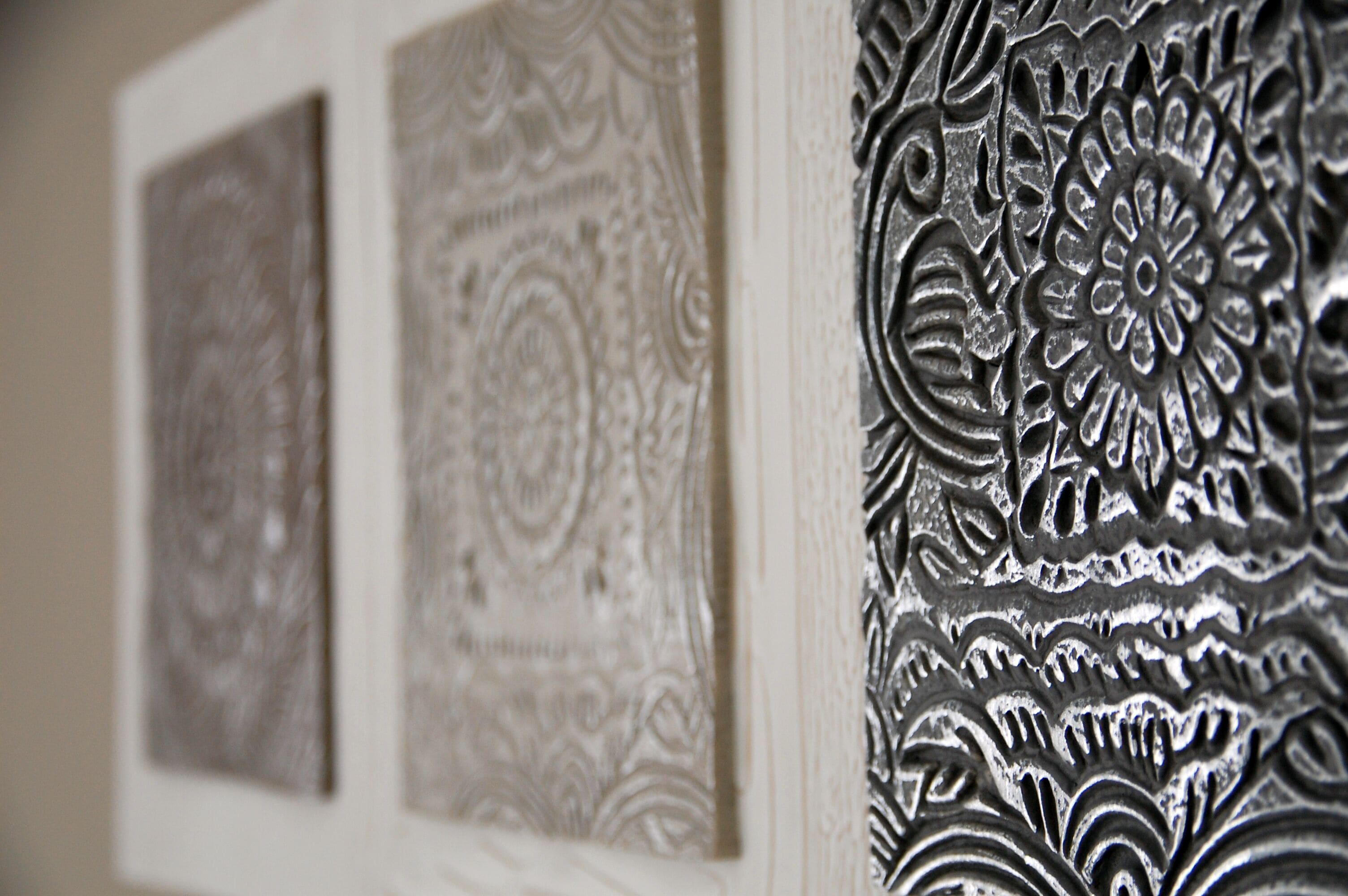 A close-up of a wall with intricate, embossed floral patterns.