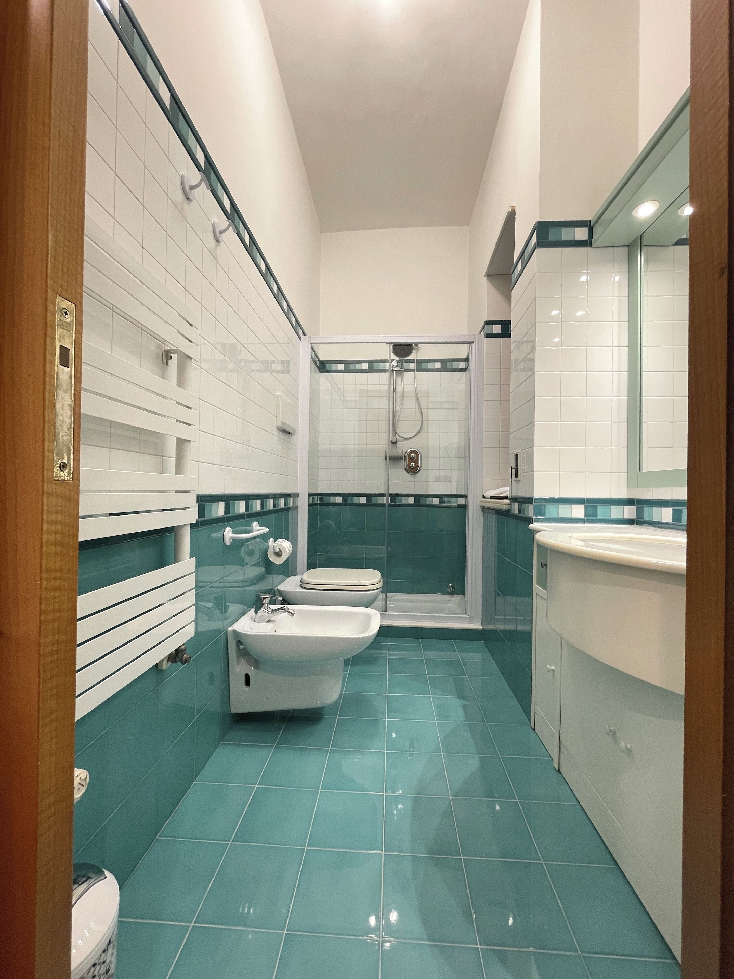 A bathroom with a glass shower enclosure, a sink, and a toilet.