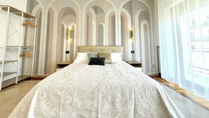 A bedroom with a large bed, a wardrobe, and a view of the outside through a window. - Dimore del Sud (Trani)