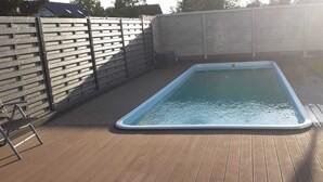 A rectangular swimming pool with a wooden deck surrounding it. - Quality vacation rental in Berlin-Kaulsdorf (Bezirk Marzahn-Hellersdorf)