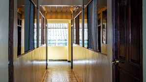 Un pasillo con suelo estampado, una puerta de madera a la derecha y una ventana al final.