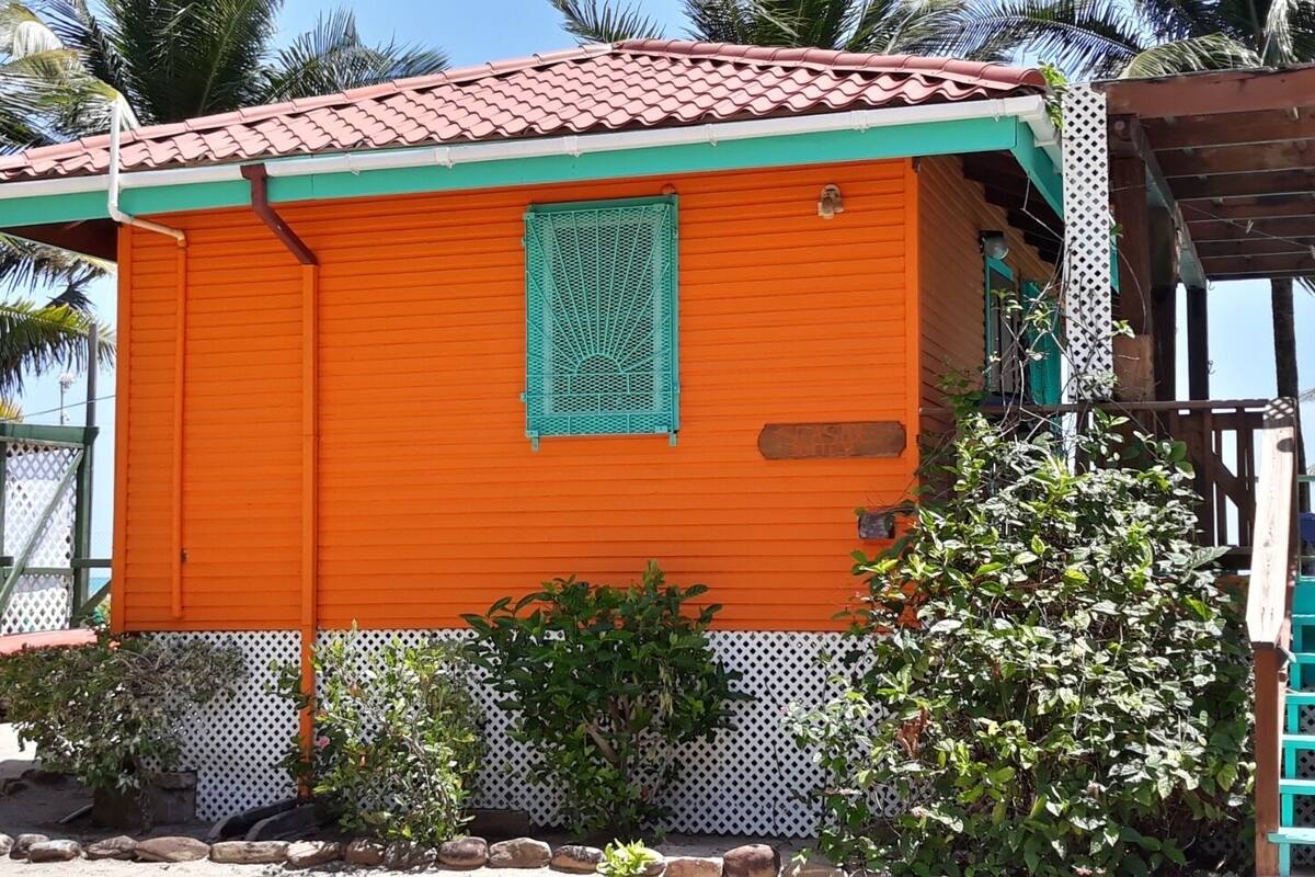 A small, single-story building with a red-tiled roof and an orange exterior.
