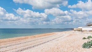 A pebble beach with a clear sky and calm sea. - Pebbles by Bloom Stays - sleeps 2 with the most amazing sea views! (Folkestone)