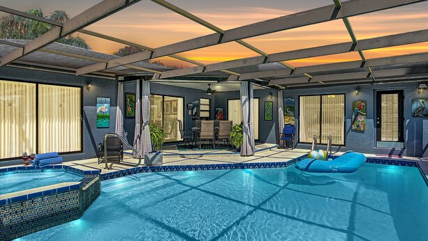 Une piscine intérieure dotée d’un espace abrité, de sièges et offrant une vue sur le coucher de soleil.