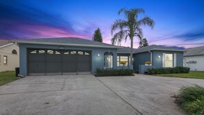 Une maison moderne à deux étages, dotée d’un garage, d’une allée bien entretenue et d’un jardin aménagé à l’avant.
