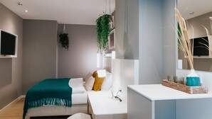 Un dormitorio moderno con cama, mesita de noche y escritorio con silla.