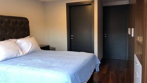 A bedroom with a bed, a nightstand, a wardrobe, and a door. - Apartment with an amazing terrace in the heart of Mexico City (México D.F)