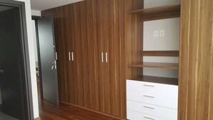 A room with a wooden wardrobe, a white dresser, and a door. - Apartment with an amazing terrace in the heart of Mexico City (México D.F)