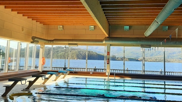 An indoor swimming pool with clear views of a lake and mountains. - Apartment on the ocean and the beach. . (santa marta de ortigueira)