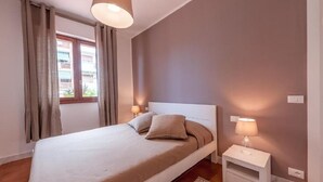 A bedroom with a bed, curtains, a bedside lamp, and a window. - Il Parco Apartments - Apartment with Terrace (Marina di Massa)