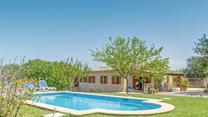 A stone house with a swimming pool, surrounded by grass and trees. - Stone-villa in a rural idyll with pool– Villa Mamici (Capdepera)