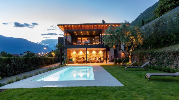 A modern house with a swimming pool, outdoor seating, and a view of the mountains. - Apartment "Innerbachlerhof Laugen" with Wi-Fi, Air Conditioning, Garden & Pool (Postal)