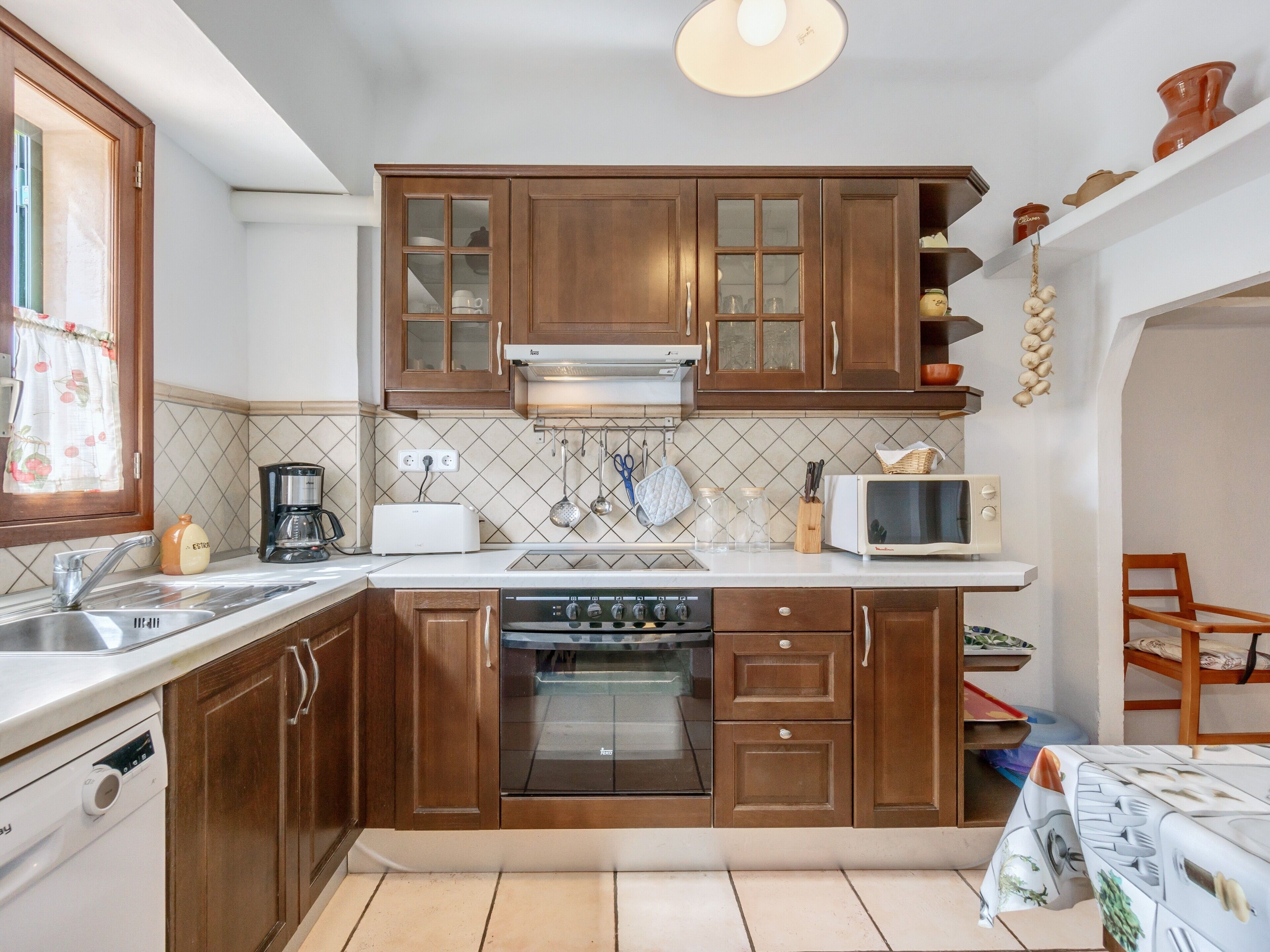 A kitchen with wooden cabinets, a microwave, a toaster, and a sink.