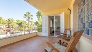 Un balcon avec vue sur les palmiers et un sol carrelé.