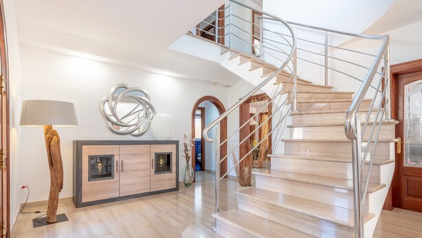 Un intérieur moderne avec un escalier en colimaçon, un meuble en bois et une lampe.