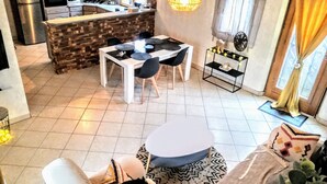 A modern kitchen with a central island, a dining area with a round table, and a living space with a sofa and a coffee table.