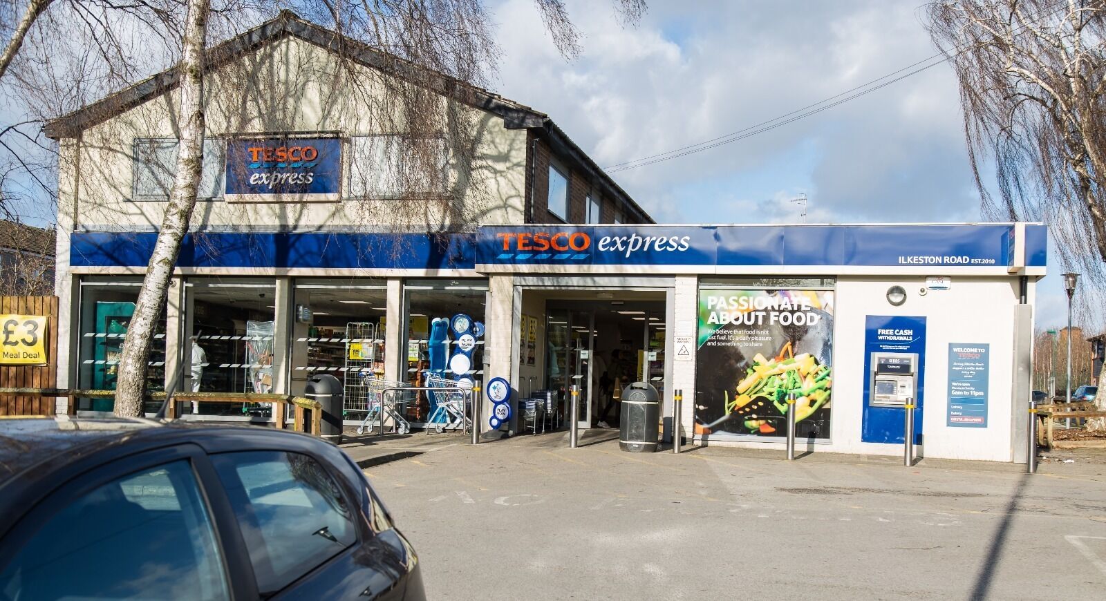 En Tesco Express butik med et tilbudsskilt for et måltid, en stor madreklame og et velkomstskilt.