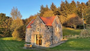 A stone house with a red roof, a small porch, and a table with chairs outside. - Beautiful Renovated Mill near Portsoy and the many beaches along the Moray Firth (Banff)