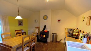 Ein gemütliches Wohnzimmer mit Kamin, Holzesstisch und Stühlen.