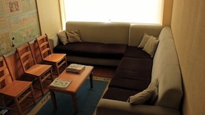 Uma sala de estar acolhedora com um sofá, cadeiras, uma mesa de centro e um mapa na parede.