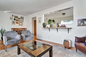 A modern living room with a glass coffee table, grey sofas, a brown leather sofa, and a bookshelf with decorative items. - Retro vibe w/ hot tub, piano lounge and vinyls (Picton)
