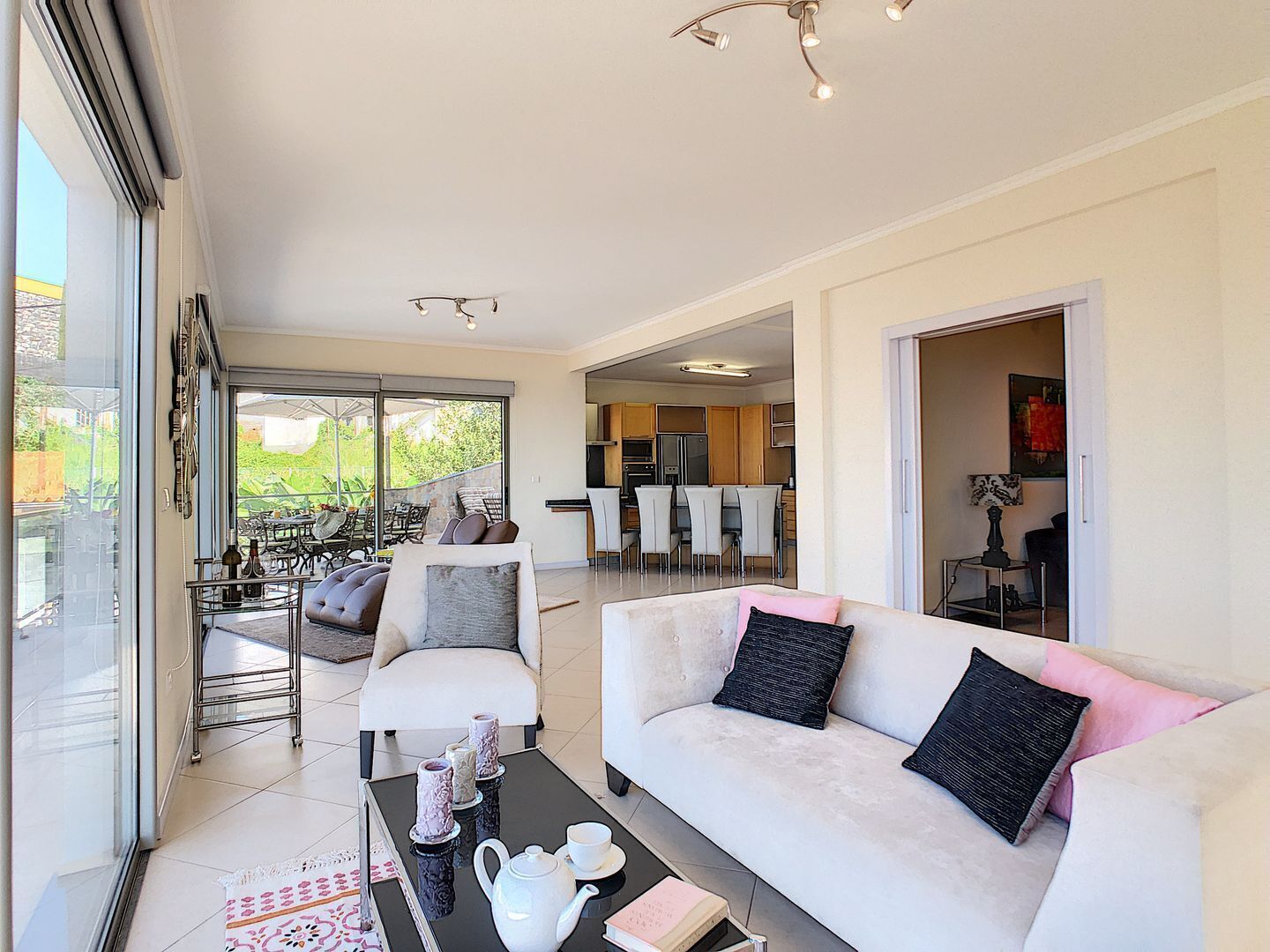 A spacious living area with a sofa, coffee table, and a dining area with chairs and a table.