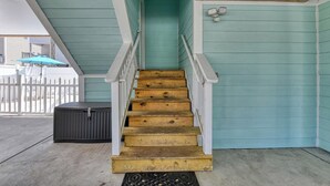 A wooden staircase with white railings leading to a door with a light blue exterior. - Dreamscaper - Five Bedroom, Four 1/2 Bath Home with private pool (Surfside Beach)