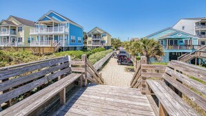 A wooden boardwalk leading to beachfront properties with multiple stories and balconies. - Dreamscaper - Five Bedroom, Four 1/2 Bath Home with private pool (Surfside Beach)