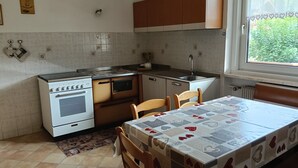 Une cuisine équipée d’une cuisinière, d’un four, d’un évier et de meubles de rangement en bois.