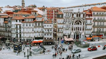 A historic square with traditional buildings, a prominent clock tower, and a busy pedestrian area.