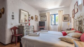 A bedroom with two beds, a dresser, a television, and a window with curtains. - Spacious Villa "Morena" with Wi-Fi, Garden, Terrace, Balcony & Pool (Albufeira)
