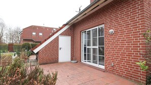 A brick house with a white door and large windows.