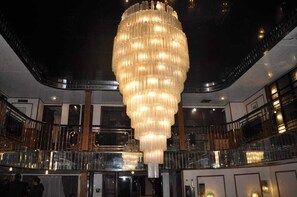 A grand chandelier in a spacious lobby with multiple levels and balconies. - Diamond ship Hotel (Cairo)