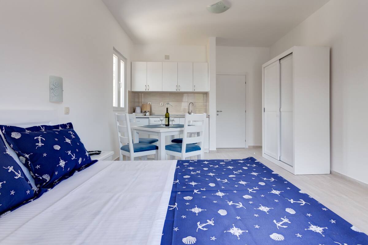 Quarto com cama, escrivaninha e cadeira, banheiro com vaso sanitário e pia, e guarda-roupa.
