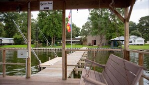 A wooden dock with a bench, a flag, and a sign that reads "Cypress Soul."