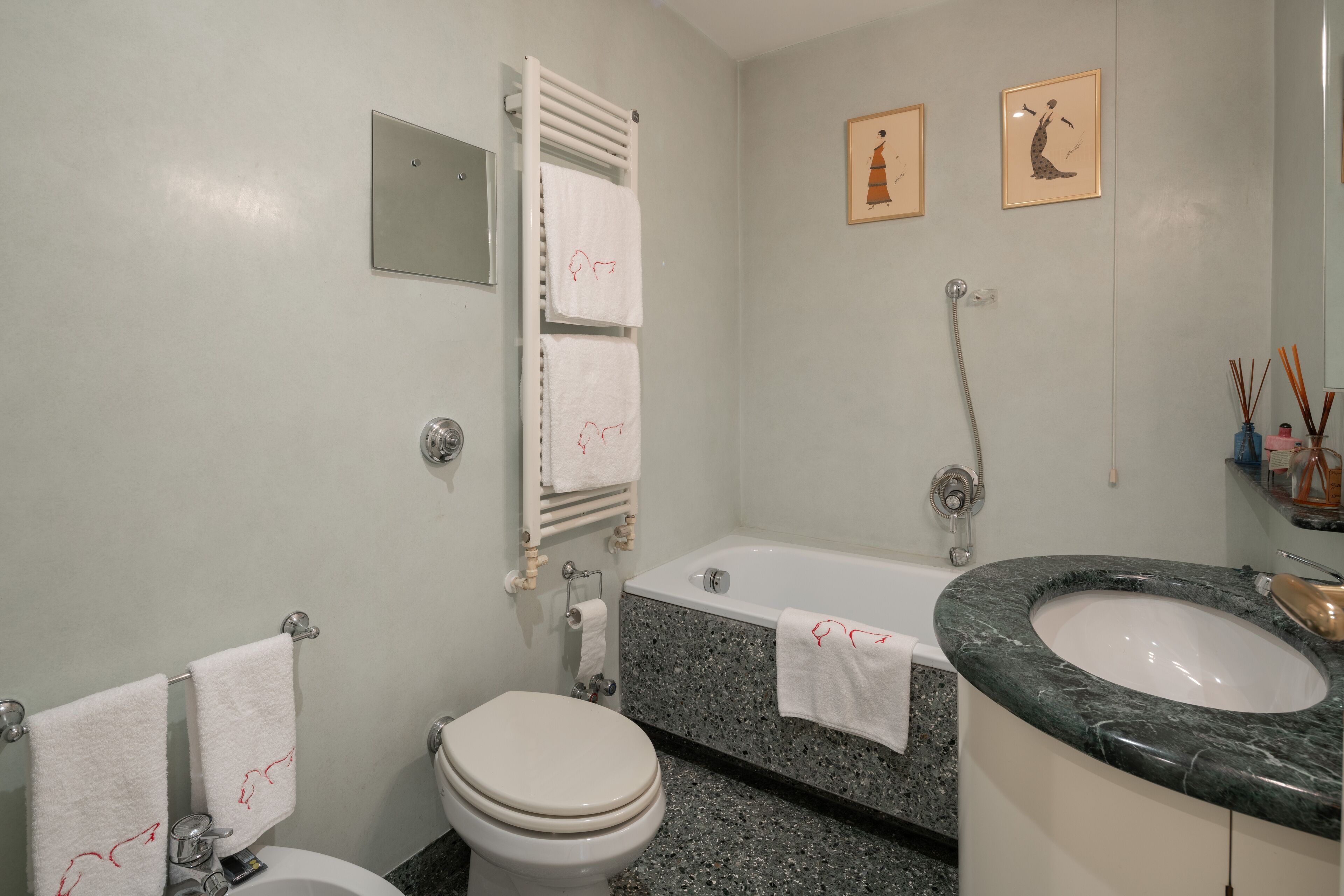 A bathroom with a toilet, sink, bathtub, and towel rack.