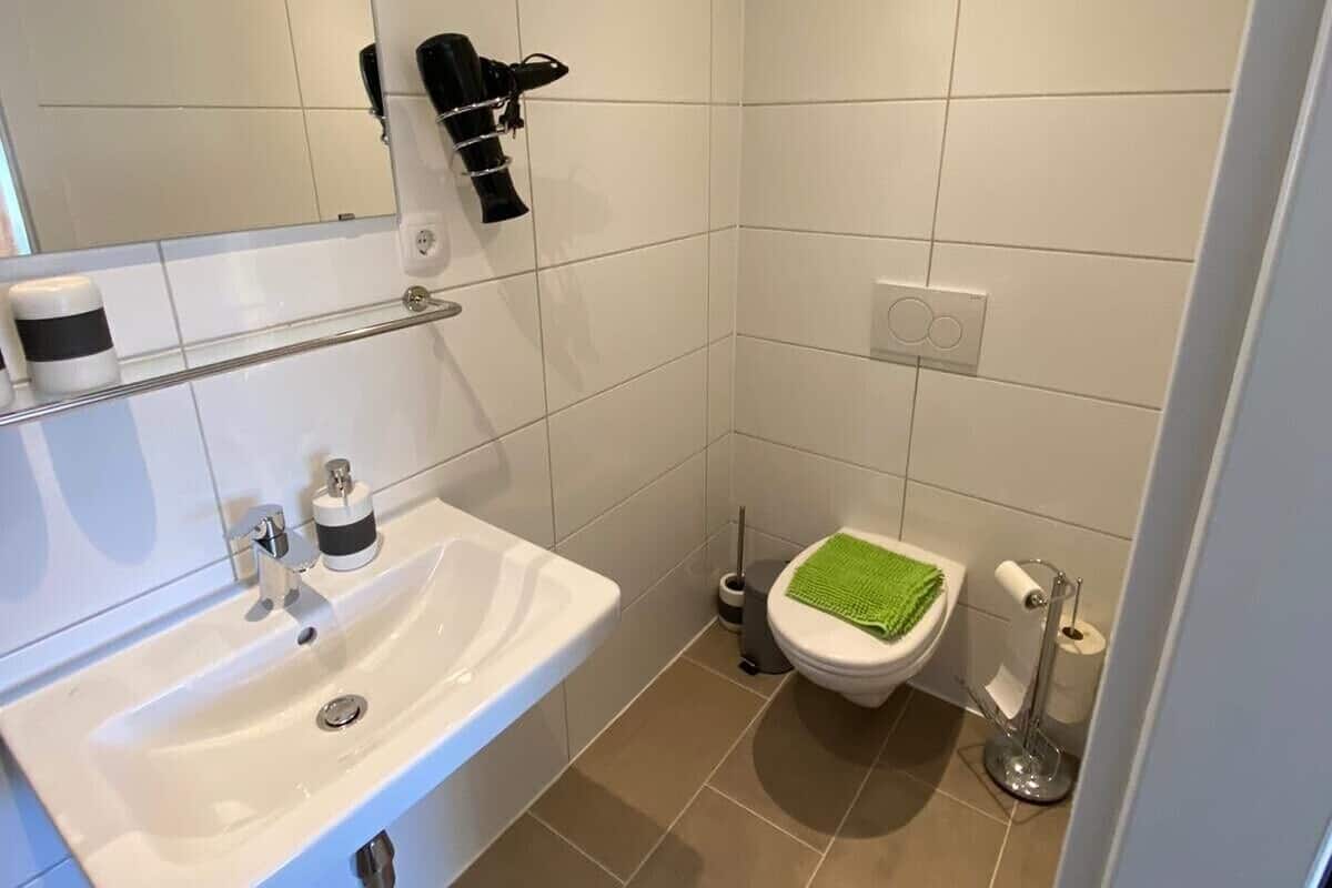 Familiekamer | Badkamer | Een douche, een haardroger, handdoeken