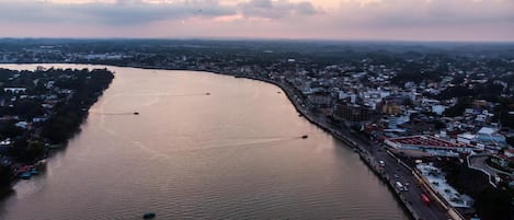 Vista aérea de un río con barcos, un puente y un paisaje urbano con edificios y carreteras.