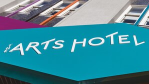 Exterior del Arts Hotel, con un cartel llamativo que muestra su nombre.