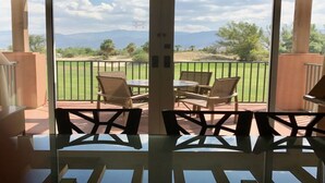 A covered patio with a view of a golf course, featuring a table and chairs. - COACHELLA FEST ... 9th- 13th April 2020 (Palm Desert)