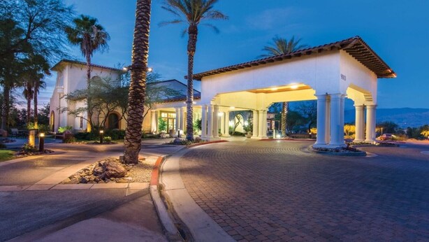 A hotel entrance with a covered patio, palm trees, and a mountainous backdrop. - COACHELLA FEST ... 9th- 13th April 2020 (Palm Desert)